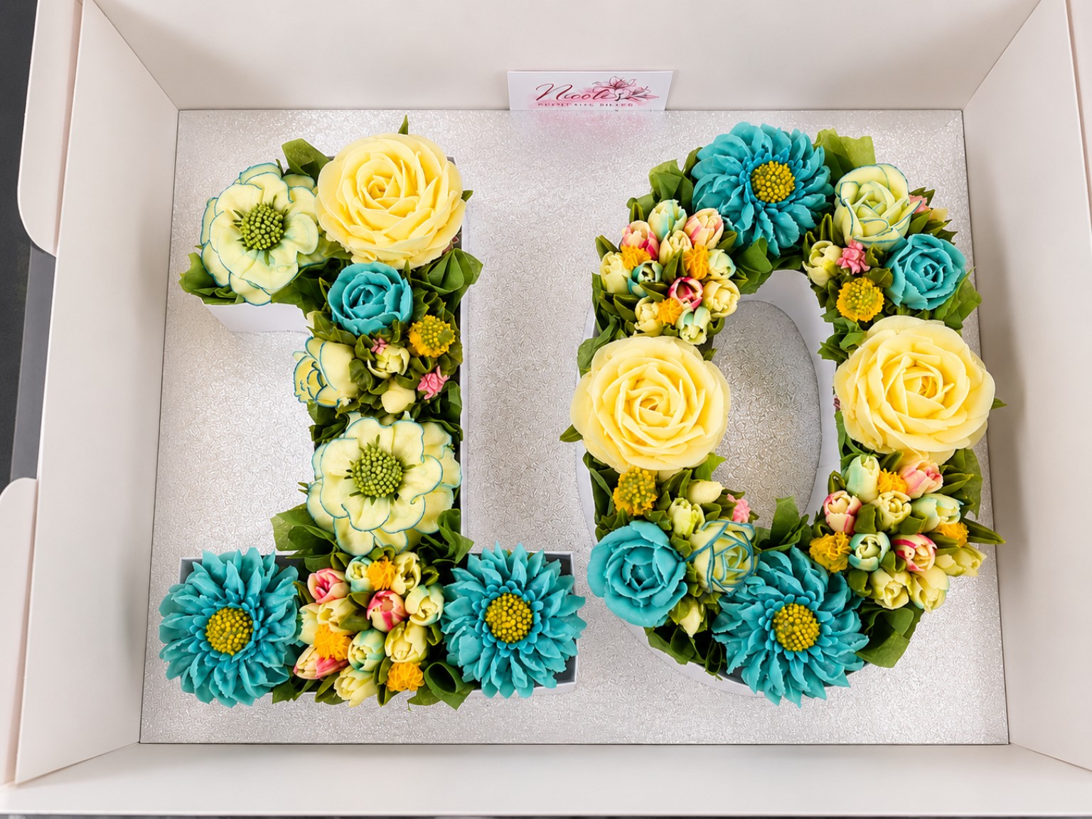 Blue and yellow floral cupcakes arranged as number 10